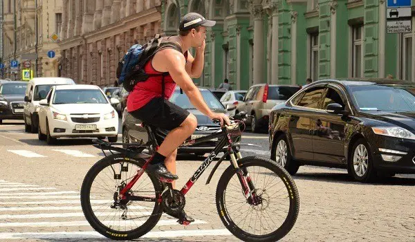 jalgrattur, kes räägib mobiiltelefoniga